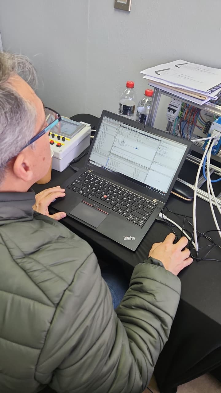 Participante diagnosticando en TIA Portal, con el tablero y el cableado de red industrial al costado