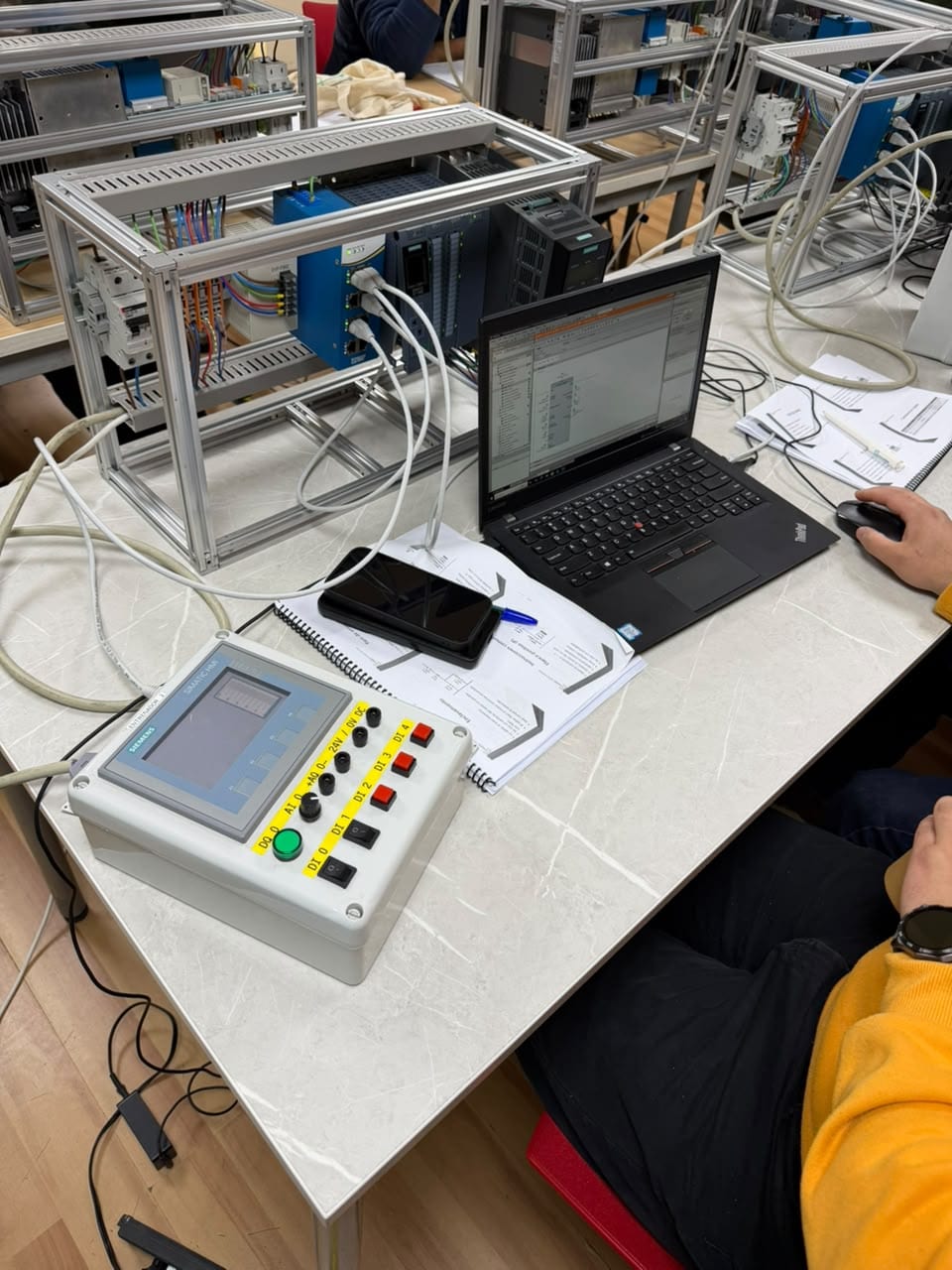 Estación de trabajo: maleta de entrenamiento con PLC Siemens, notebook con TIA Portal, entrenador con panel HMI y la guía de laboratorios